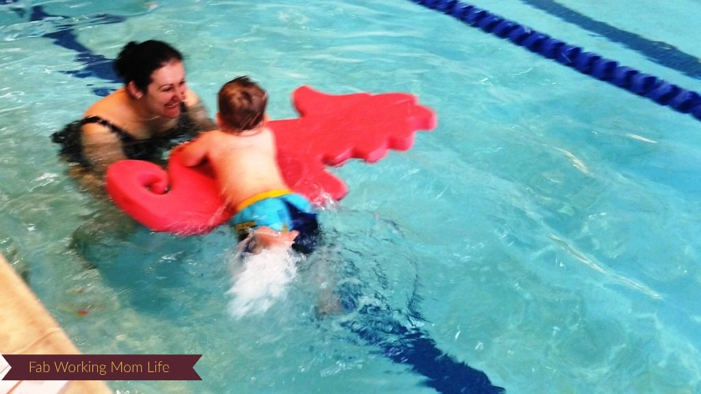 Baby H kicking while holding onto a seahorse floatie.