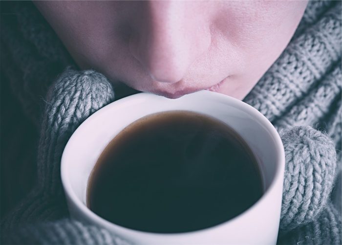 woman sipping coffee to help her stay awake