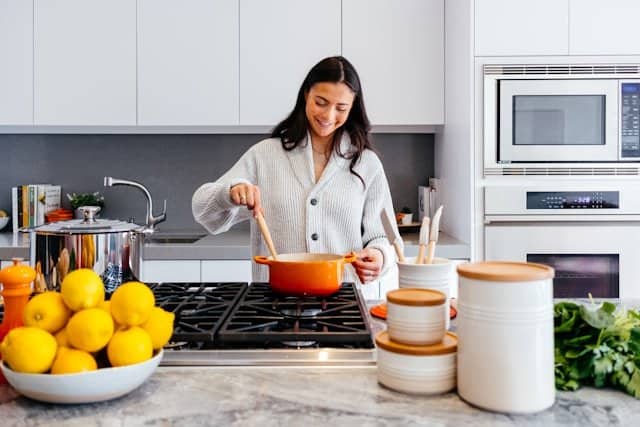 Quick and tasty BBQ chicken recipes designed to suit the hectic lifestyle of a busy working mom. Transform your weeknight dinners with these flavorful, time-saving BBQ chicken ideas that are sure to please the whole family. Picture of woman cooking inside kitchen room